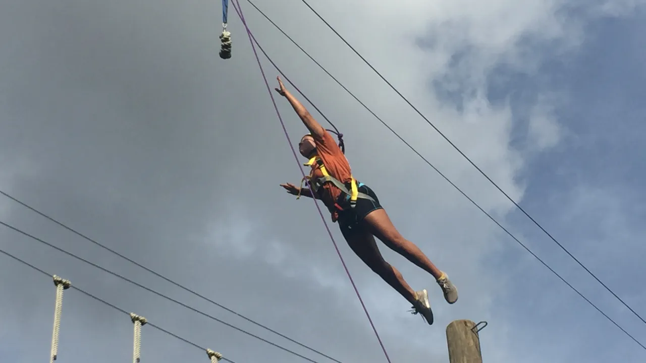 Person leaps for a bandana off of a telephone pole wearing safety equipment