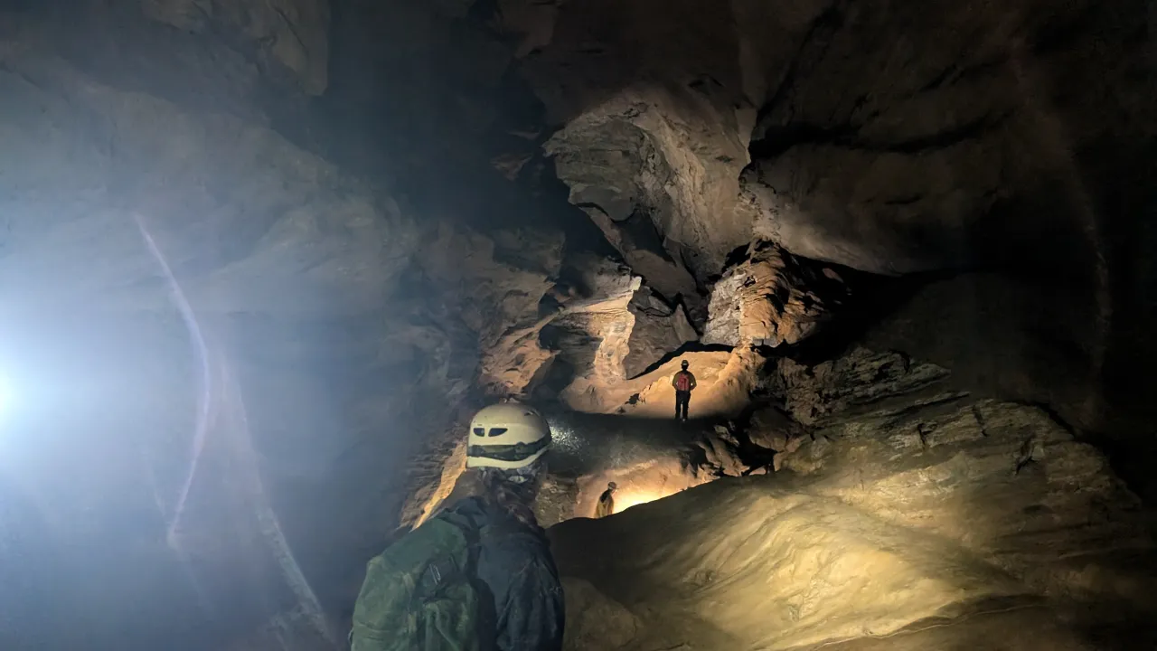 Person looking off into a lit underground cave