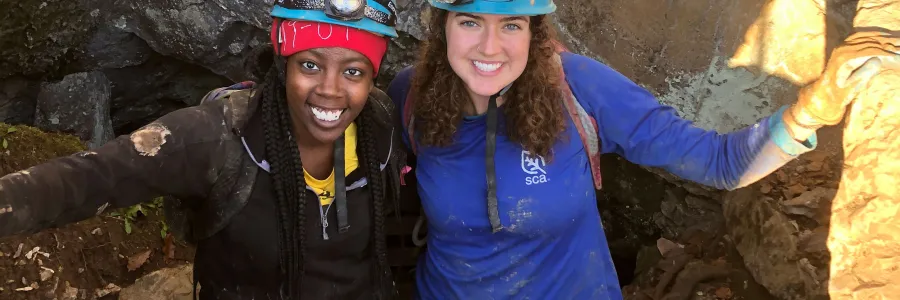 two women standing in a cave