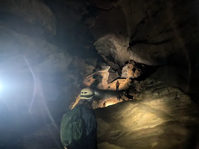 Person looking off into a lit underground cave