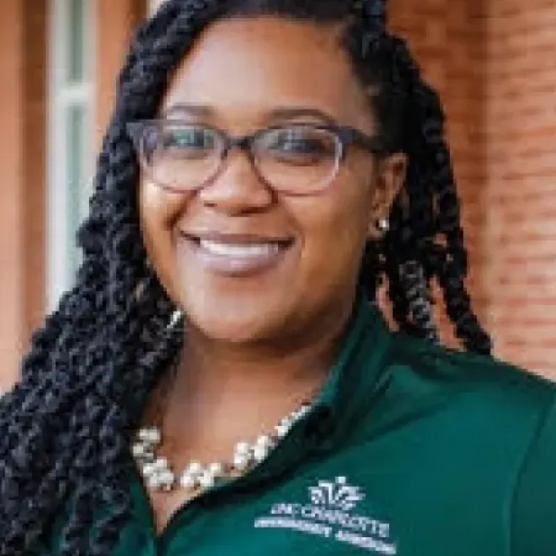 Female presenting person smiles at the camera 